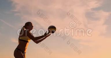 沙滩排球发球-女子发球在沙滩排球比赛. 上面的钉子发球。 年轻人在娱乐
